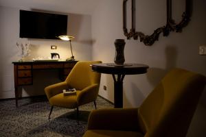 a room with a table and two chairs and a desk at Hotel Villa Taormina in Taormina