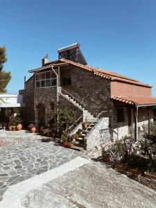 un edificio in pietra con una scala che lo porta di Andreas Village 2 ad Achladies