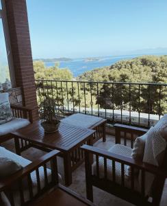 a balcony with tables and chairs and a view of the ocean at Andreas Village 2 in Achladies