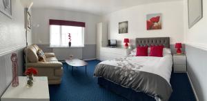 a bedroom with a bed and a couch and a chair at Chateau Dale Holiday Apartments in Blackpool