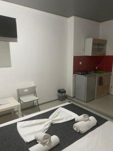 a room with towels on the floor and a kitchen at Petska Apartments in Leptokarya