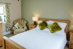 a bedroom with a white bed and a chair at Newsham Grange Farm in Thirsk +46 photos