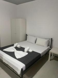a bed with white towels on it in a room at Petska Apartments in Leptokarya