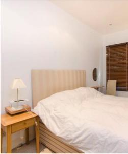 1 dormitorio con 1 cama y 1 mesa con lámpara en spacious Knightsbridge flat, en Londres