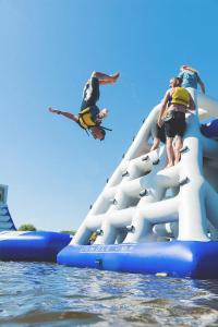 eine Gruppe von Menschen auf einer Wasserrutsche im Wasser in der Unterkunft Fistral hot tub house for 8 on Retallack Resort in Newquay