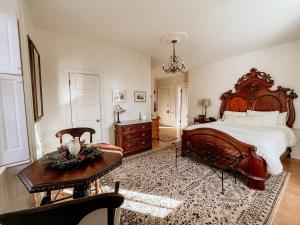 Un dormitorio con una gran cama de madera y una mesa. en Mayhurst Estate, en Orange