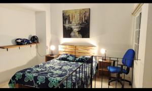 een slaapkamer met een bed en een blauwe stoel bij Parrot House San Antonio in Cali