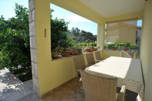 a patio with a table and chairs on a balcony at Brna Three-room apartment near the beach-Zen in Brna