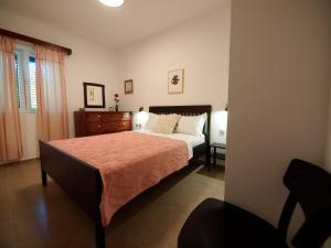 a bedroom with a bed and a dresser and a chair at Brna Three-room apartment near the beach-Zen in Brna