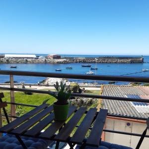 a bench on a balcony with a view of the ocean at Apartamento Reguiño al mar in A Guarda