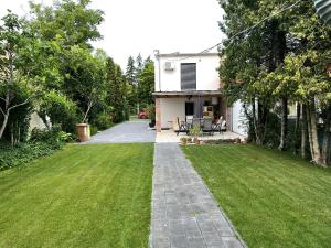 シオーフォクにあるHouse for 6 ppl at Lake Balatonの緑の芝生と私道のある家