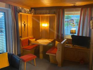 a small living room with a table and a television at Haus am Achengrund in Kössen