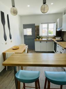une cuisine avec une table en bois et des chaises bleues dans l'établissement Casa do Carmo, à Sousel