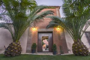 a building with two palm trees in front of it at Finca Villa Juan in Ribera del Fresno