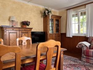 a dining room with a wooden table and a television at Zur Kanne für 3-4 Personen in Trichtingen