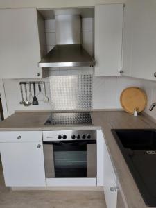 a kitchen with white cabinets and a stove top oven at Ferienwohnung Thamm in Lage