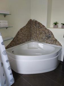 a white bath tub sitting in a bathroom at Ferienwohnung Thamm in Lage +8 photos