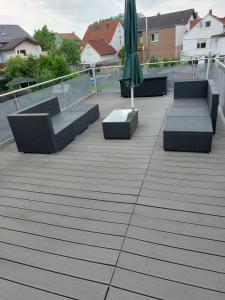 eine Terrasse mit Stühlen, einem Sonnenschirm und einem Tisch in der Unterkunft Ferienwohnung Thamm in Lage