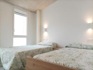 Un dormitorio con dos camas y una ventana. en Casa Bayer, en Benicàssim