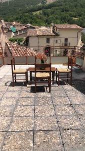 patio z 2 ławkami i stołem na balkonie w obiekcie La Casa del Lupo w mieście Collimento