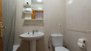 Un baño blanco con lavabo e inodoro. en Views of El Medano beach, two, en El Médano 17 fotos más
