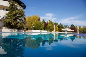 a swimming pool with blue water and a building at New Egreta Resort in Dunavăţu de Jos