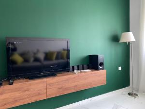 a flat screen tv sitting on top of a wooden entertainment center at Lovely 4-bedroom condo with pool in Rabat