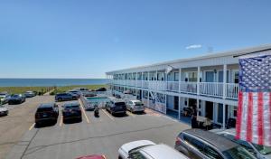 a hotel with cars parked in a parking lot at On the Beach Motel in Old Orchard Beach