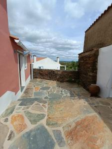 a patio with a stone floor and a building at Casa Torta in Outeiro