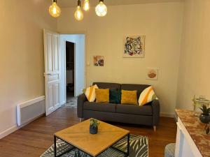 salon z kanapą i stołem w obiekcie Très bel appartement tout proche du centre ville w mieście Montélimar