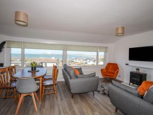 a living room with a table and chairs and a television at Ty Melyn in Rhosneigr