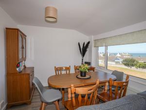 a dining room with a table and chairs and a window at Ty Melyn in Rhosneigr