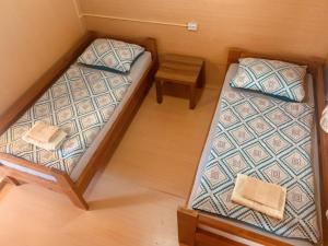 two beds in a small room with a table at Bungalow Perun in Blejska Dobrava