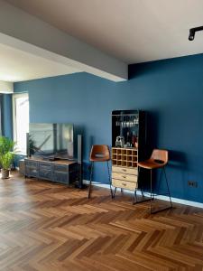 una habitación con dos taburetes y una pared azul en Vila Casa9, en Eşelniţa