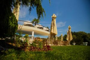 a group of chairs and umbrellas in front of a building at New Egreta Resort in Dunavăţu de Jos