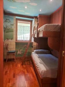 um quarto com 2 beliches e uma janela em Il nido incantato em Andalo