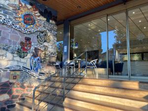 a home with a colorful mosaic wall and stairs at Hôtel Christina Lourdes in Lourdes