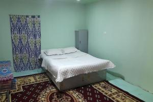 a small bed in a room with a rug at FOREST Guest House in Mirzakishlak +26 photos
