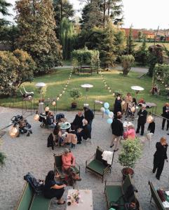 een groep mensen die in stoelen in een tuin zitten bij Villa Biondelli Wine & Suites in Cazzago San Martino