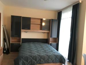 a bedroom with a bed and a large window at Студио Приятели in Tsarevo