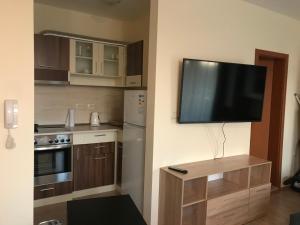 a kitchen with a flat screen tv on the wall at Студио Приятели in Tsarevo