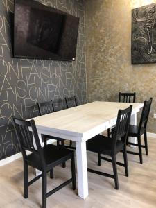 une table et des chaises blanches dans une chambre avec un mur dans l'établissement Espacio Room Fuerteventura, à Puerto del Rosario