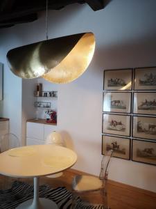 una sala da pranzo con tavolo e luce a ciondolo di Romantik, charming house a Trieste