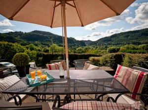 a table with an umbrella on a patio at Llety Betws in Betws-y-coed