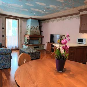 uma sala de estar com uma mesa e uma cozinha com lareira em Il nido incantato em Andalo