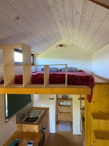 um pequeno quarto com um beliche e um lavatório em tiny house du poulloguer em Prat