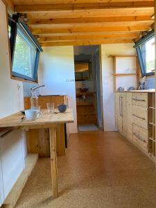 tiny house du poulloguer في Prat: مطبخ بدولاب خشبي وطاولة خشبية