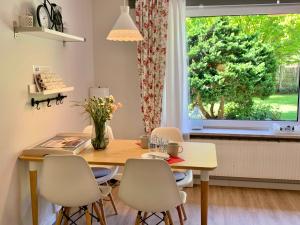jadalnia ze stołem i krzesłami oraz oknem w obiekcie Ferienwohnung 4 im Haus Windjammer w mieście Sankt Peter-Ording