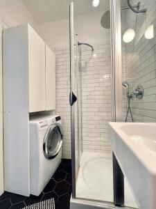 a bathroom with a washing machine and a sink at Two-story Old Town Apartment in Toruń