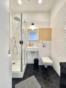 uma casa de banho com um chuveiro, um lavatório e um WC. em Two-story Old Town Apartment em Toruń